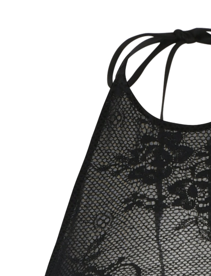 Close-up of the LUCIA DRESS - BLACK : LACE from TIGERMIST, featuring intricate floral patterns. The fabric appears delicate and elegant, with thin straps visible at the top of the image, suggesting it may be a piece of lingerie or a decorative top.