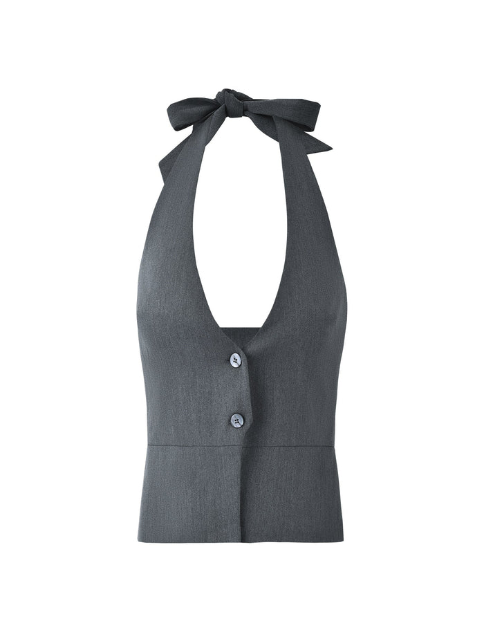The TRISTAN VEST - GREY by TIGERMIST is a sleeveless halter top made of textured fabric, featuring a deep V-neckline. It is designed with two buttons down the front and a wide tie at the neck that forms a bow. The straight bottom hemline provides a polished, tailored look.