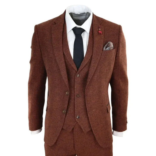 Men's brown herringbone tweed suit with blazer, waistcoat, and trousers, paired with a white shirt and black tie, detailed with pocket square and lapel pin