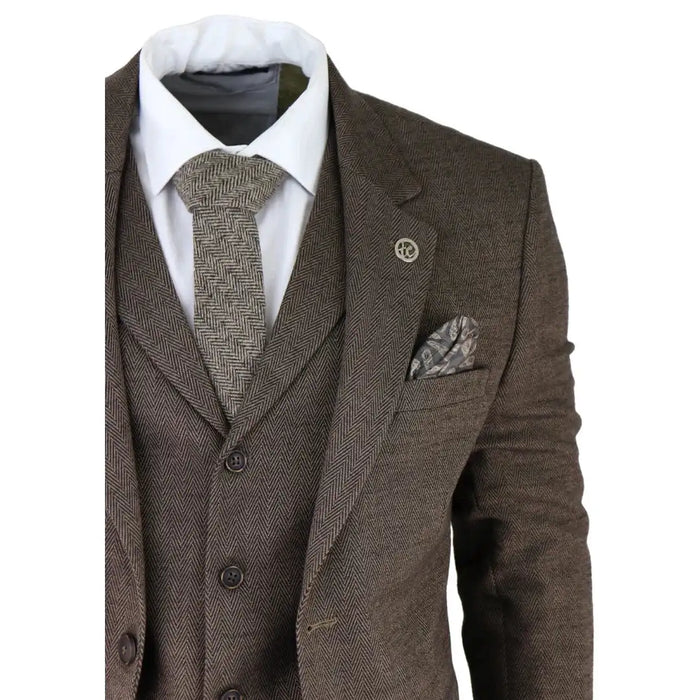 Men's brown herringbone tweed suit with blazer, waistcoat, and matching trousers, paired with a white shirt and patterned tie, tailored fit