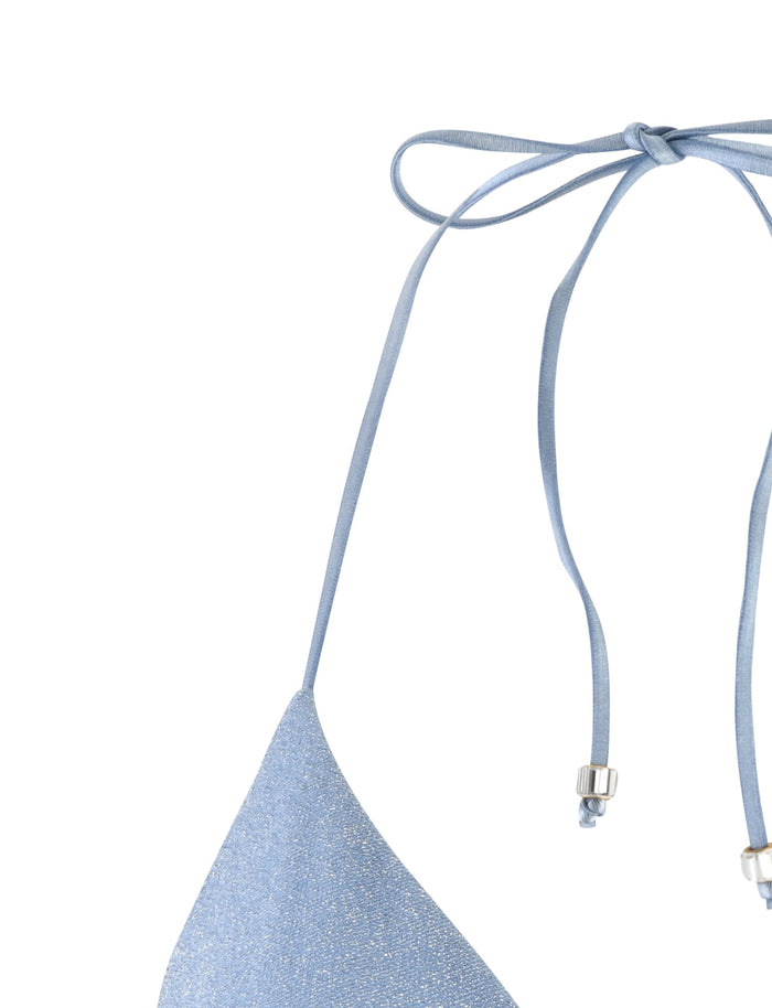 Close-up of the AVE BIKINI TOP - BLUE SPARKLE by TIGERMIST. It features thin straps that tie around the neck and a metal fastener detail on each strap. The fabric has a delicate shimmer, giving it a slightly textured appearance.