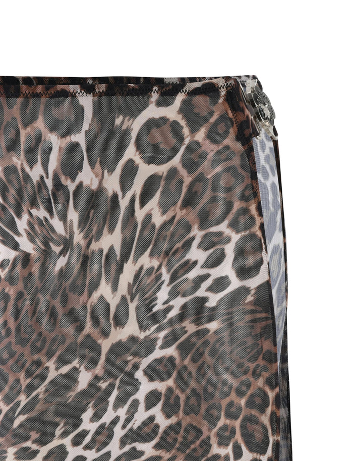 Close-up of the Cynthia Mini Mesh Skirt from TIGERMIST, featuring a leopard print pattern in shades of brown, black, and white. The fabric drapes at the top right edge and is stitched with a visible hem, suggesting this chic piece might easily complement any wardrobe.