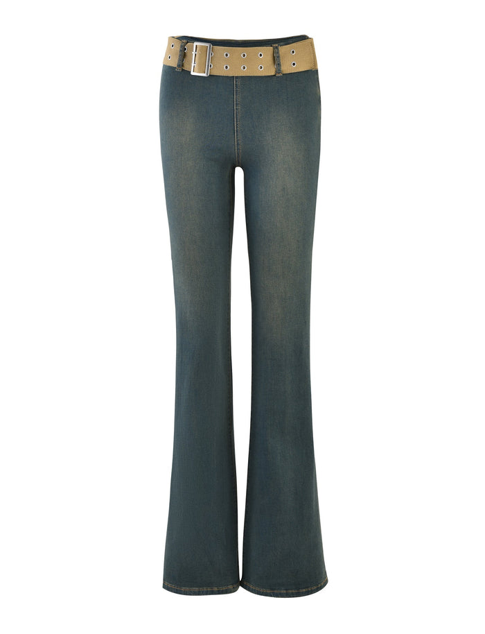 A pair of ISABEL JEANS in denim blue from TIGERMIST, featuring a light brown belt with a large metal buckle and multiple eyelets. These flared jeans have a worn-in, casual appearance with subtle fading on the thighs and knees.