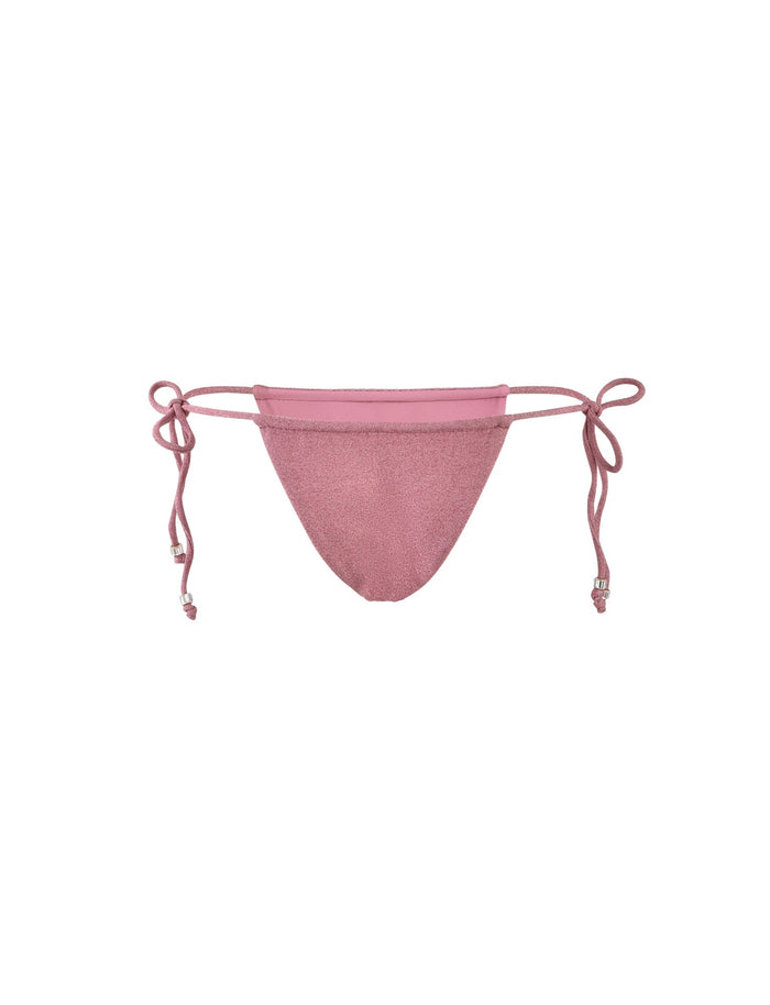 The MARIEL BIKINI BOTTOM - PINK : PINK SPARKLE from TIGERMIST is a pink bikini bottom featuring side tie strings and a glittery fabric finish. It offers minimal coverage with adjustable ties on both sides.