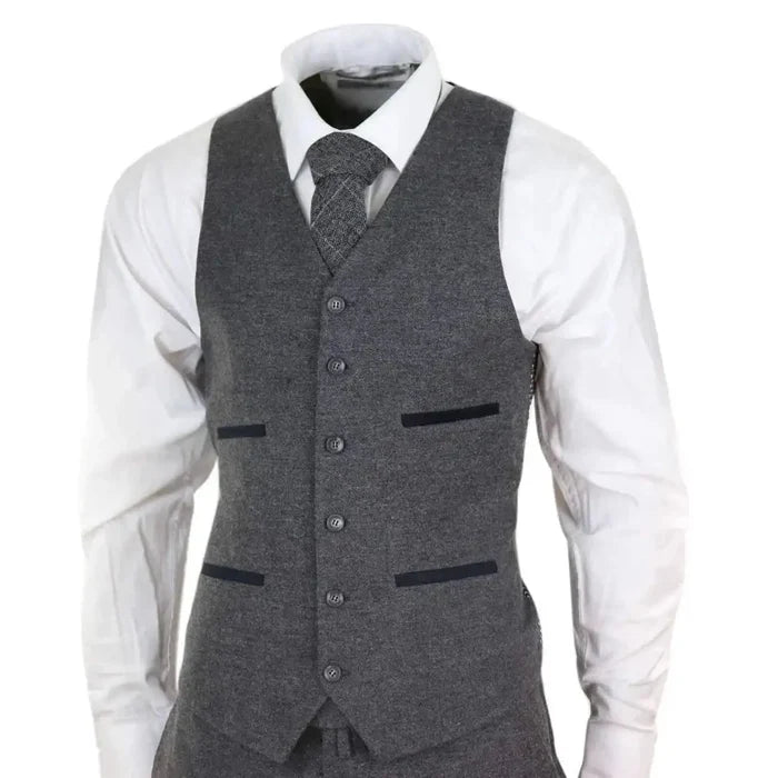 Men's grey wool tweed three-piece suit with tailored fit, includes blazer, waistcoat, and trousers, styled with a white shirt and matching tie