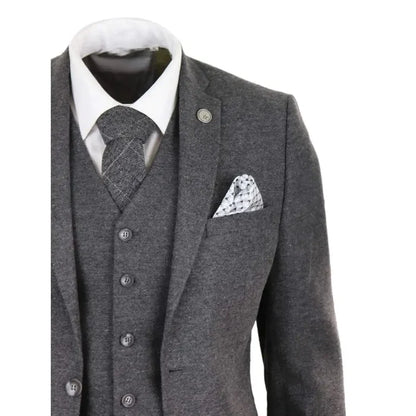 Close-up of men's grey wool tweed waistcoat with black trim, paired with a white shirt and patterned tie, showcasing classic vintage style