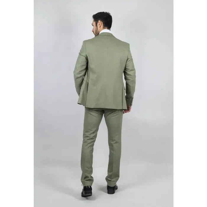 Back view of a man in a light green tailored suit with a matching blazer and pants, standing against a plain background, showcasing the stylish men's suit.