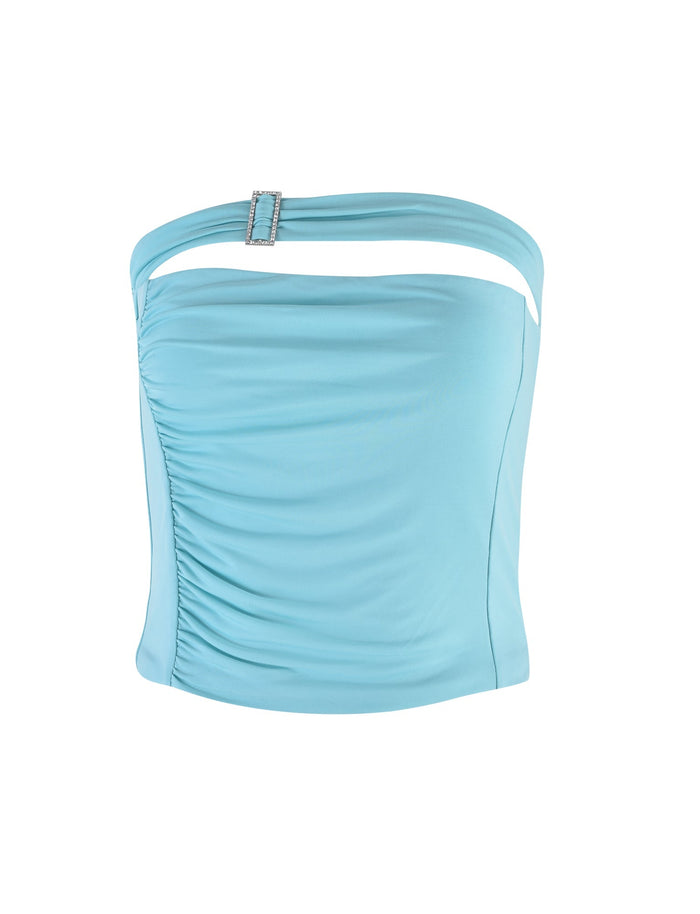 The VERANIQUE TOP - BLUE by TIGERMIST is a strapless light blue top featuring a ruched design on the left side and a single strap adorned with a rectangular buckle on the right side. It has a smooth texture and offers a fitted silhouette.