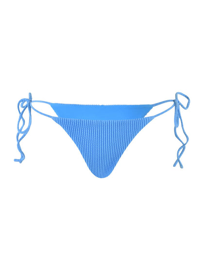 The YVE BIKINI BOTTOM - BLUE : ROYAL BLUE from TIGERMIST is a pair of blue ribbed bikini bottoms with adjustable side ties. The fabric has a textured appearance, and the design features a classic cut. The ties are shown in bows on each side, allowing for a customizable fit.